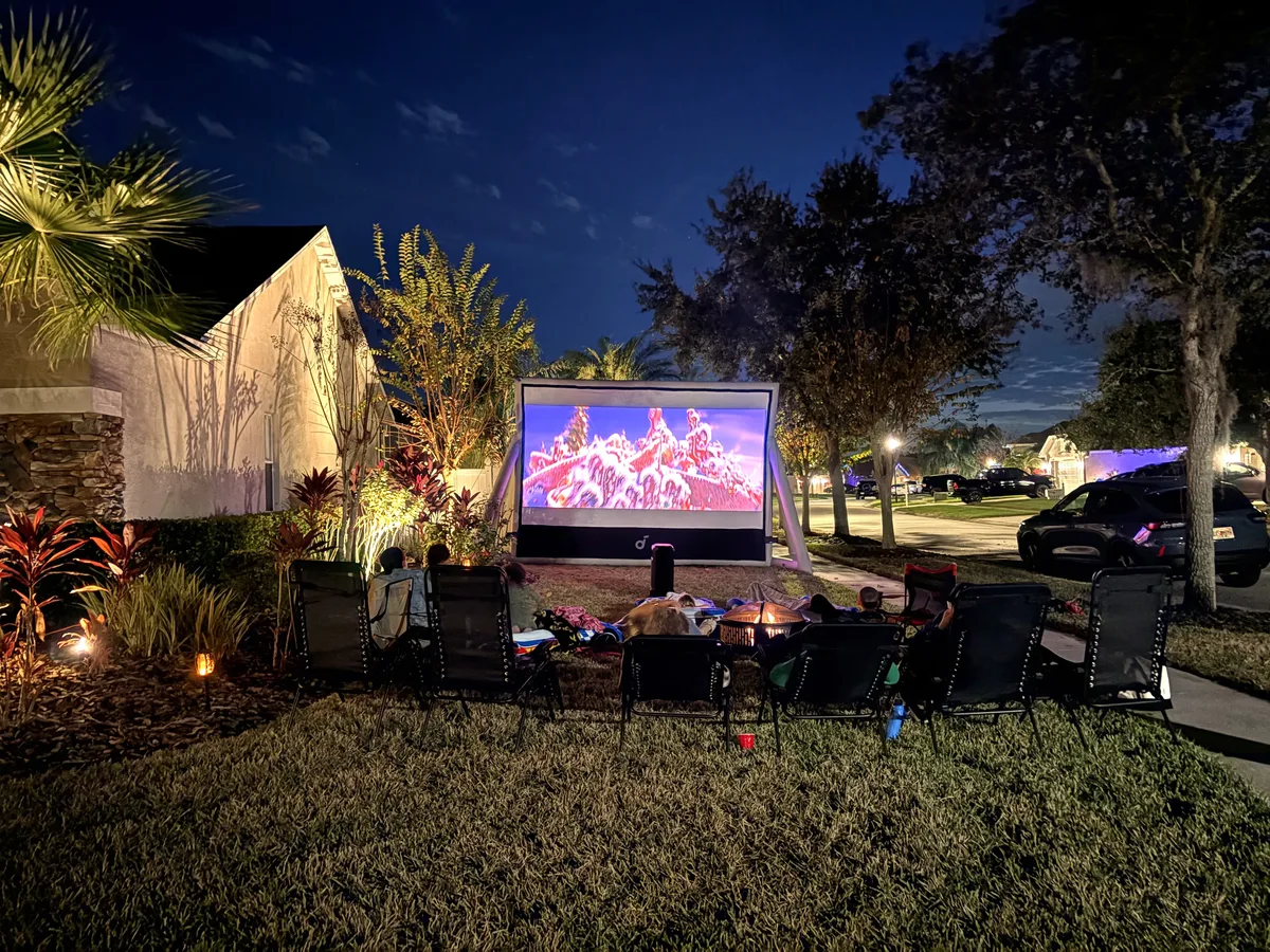 200-inch outdoor cinema screen glowing in a Tampa Bay front yard at night